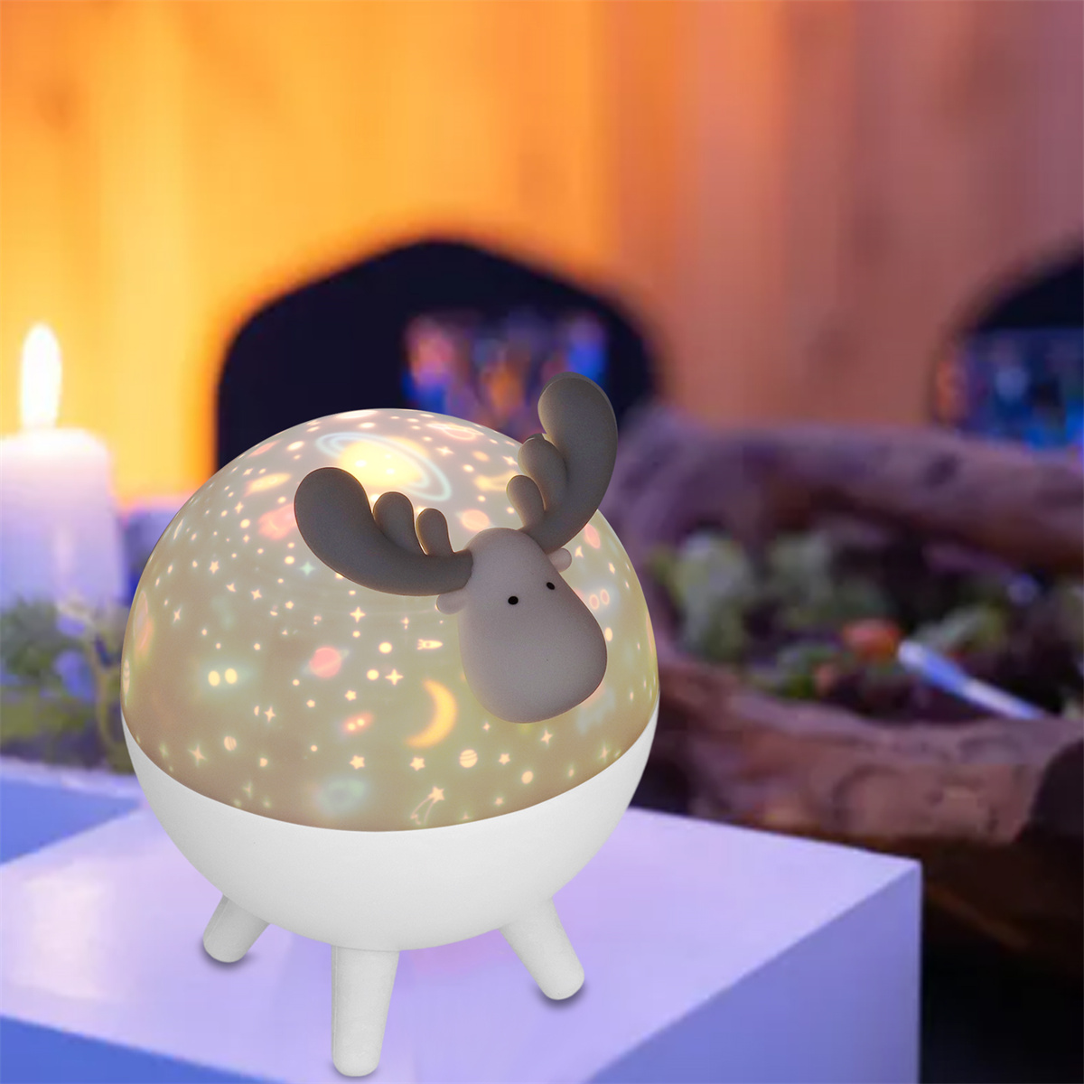 Eine schneekugelartige Lampe mit einem Hirsch oben. Sie steht auf einem Tisch mit verschwommenem Hintergrund.