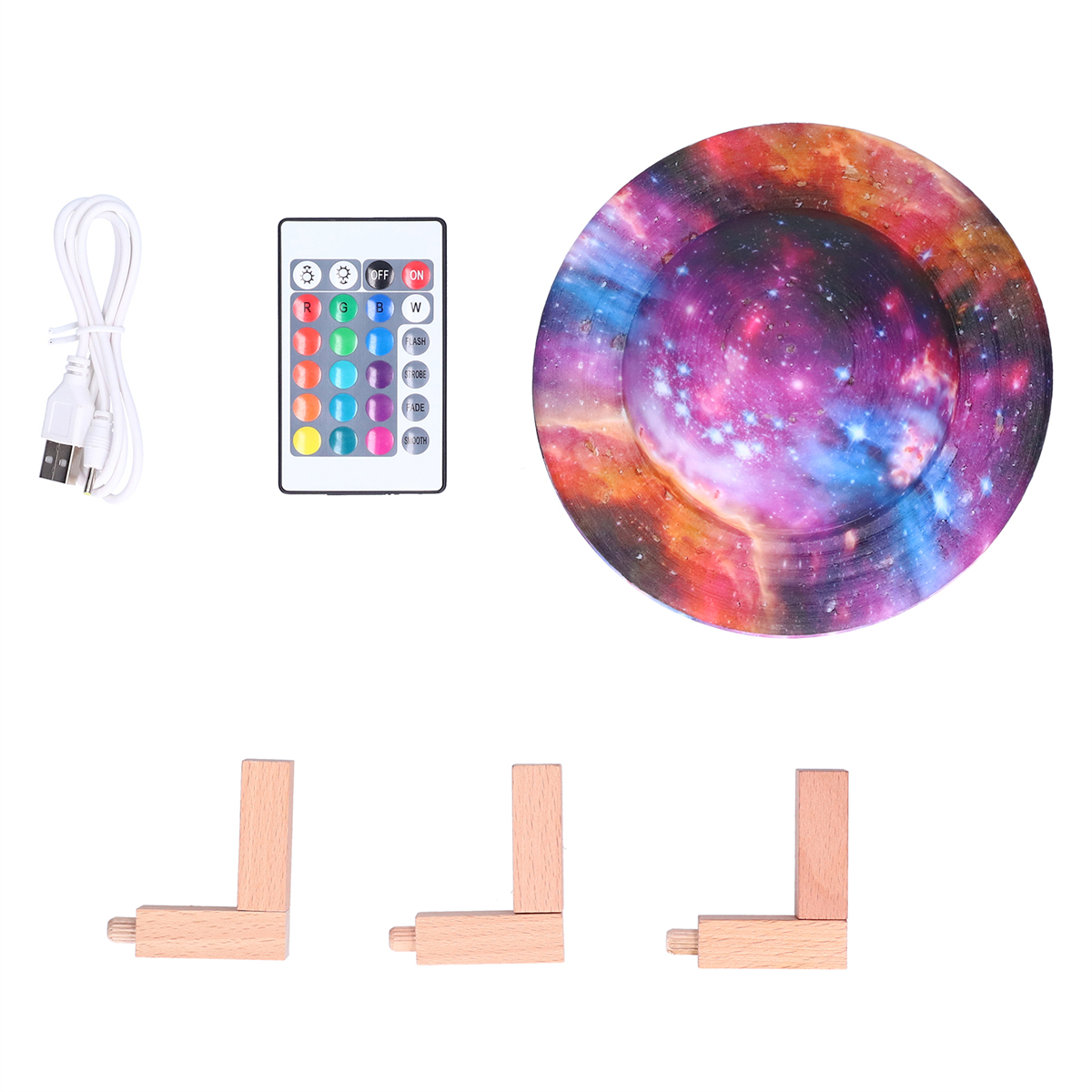 Ein Set mit USB-Kabel, Fernbedienung und einem farbenfrohen Licht im Galaxien-Design. Es gibt auch Holzstützen.