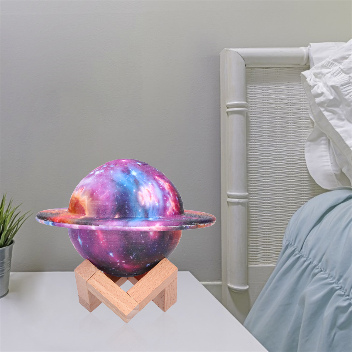 Eine planetenförmige Lampe mit Ständer, vor grauem Wandhintergrund.
