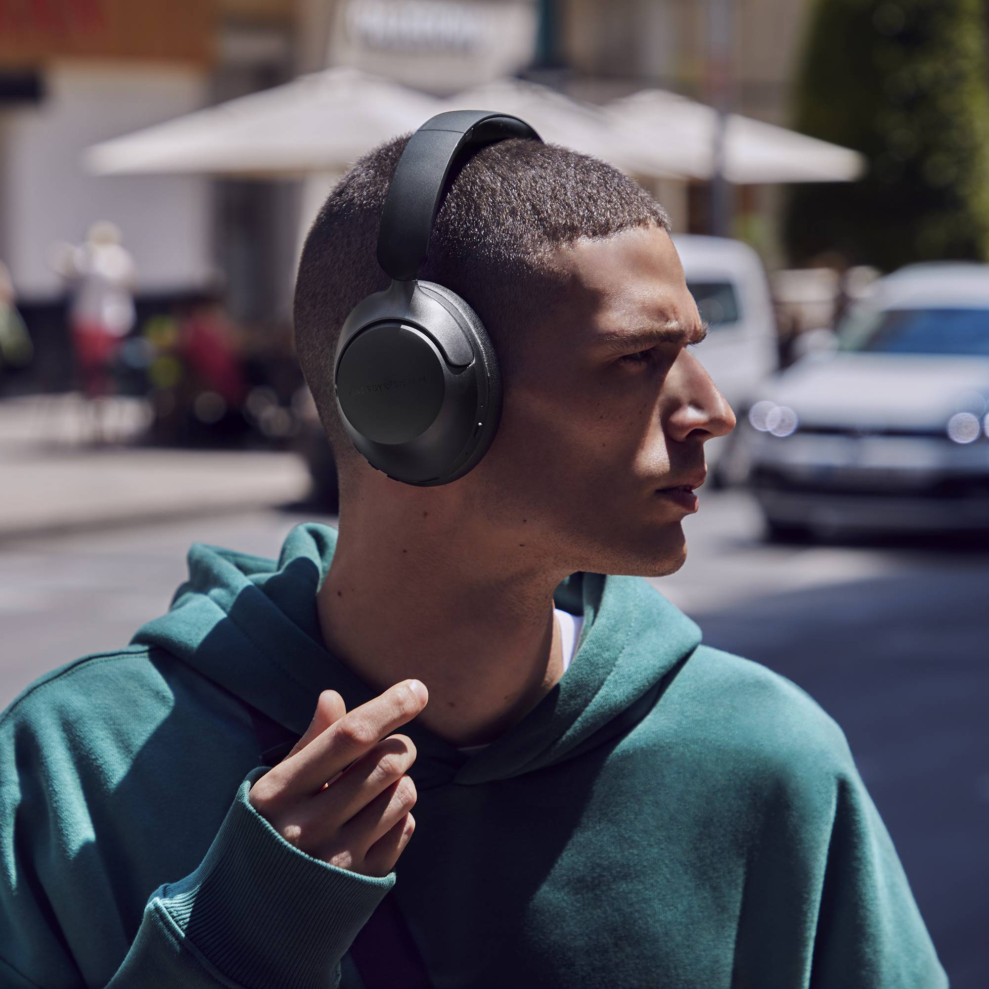 Uomo con le cuffie in una strada cittadina.