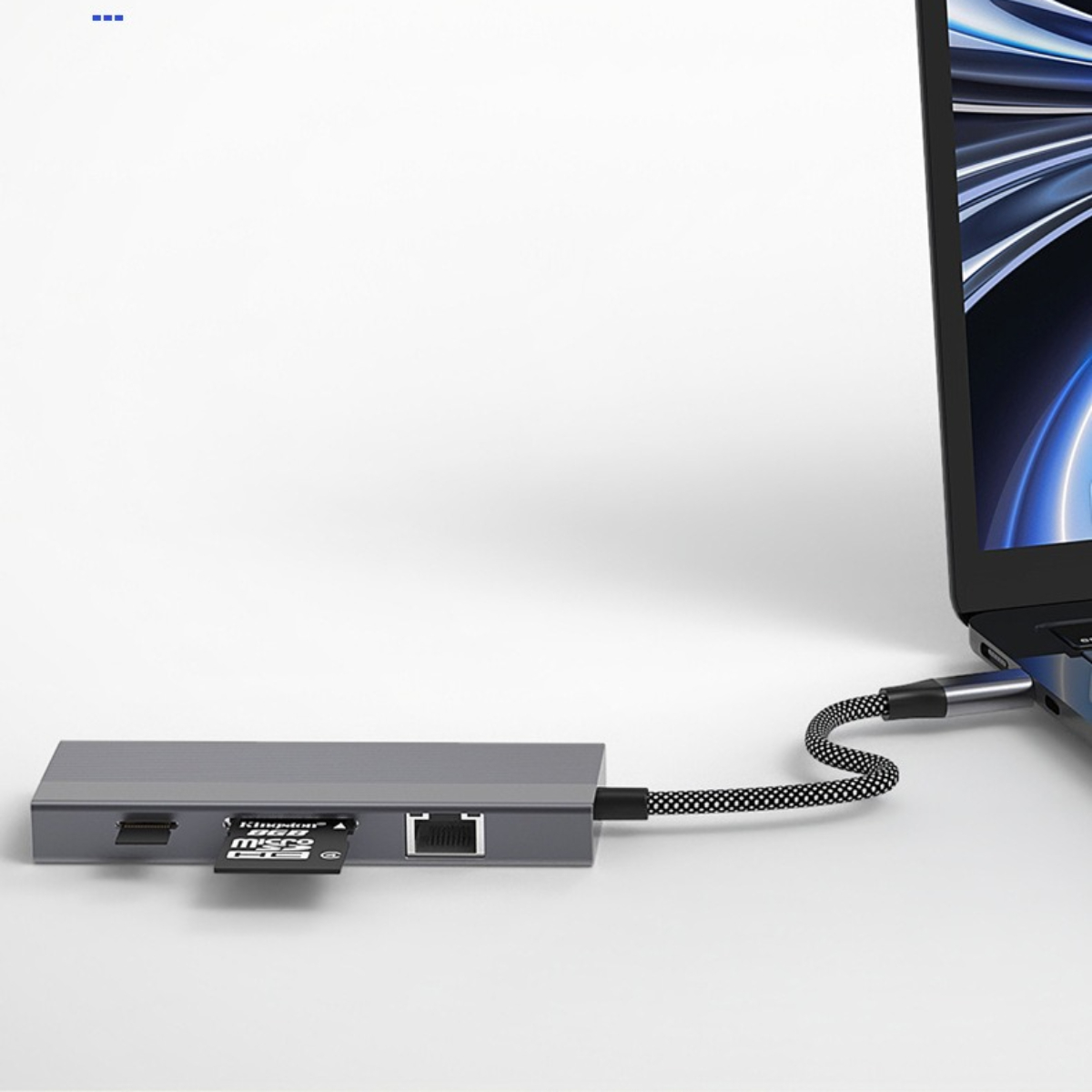 Ein silberner Hub mit einem Laptop und einem Kabel.