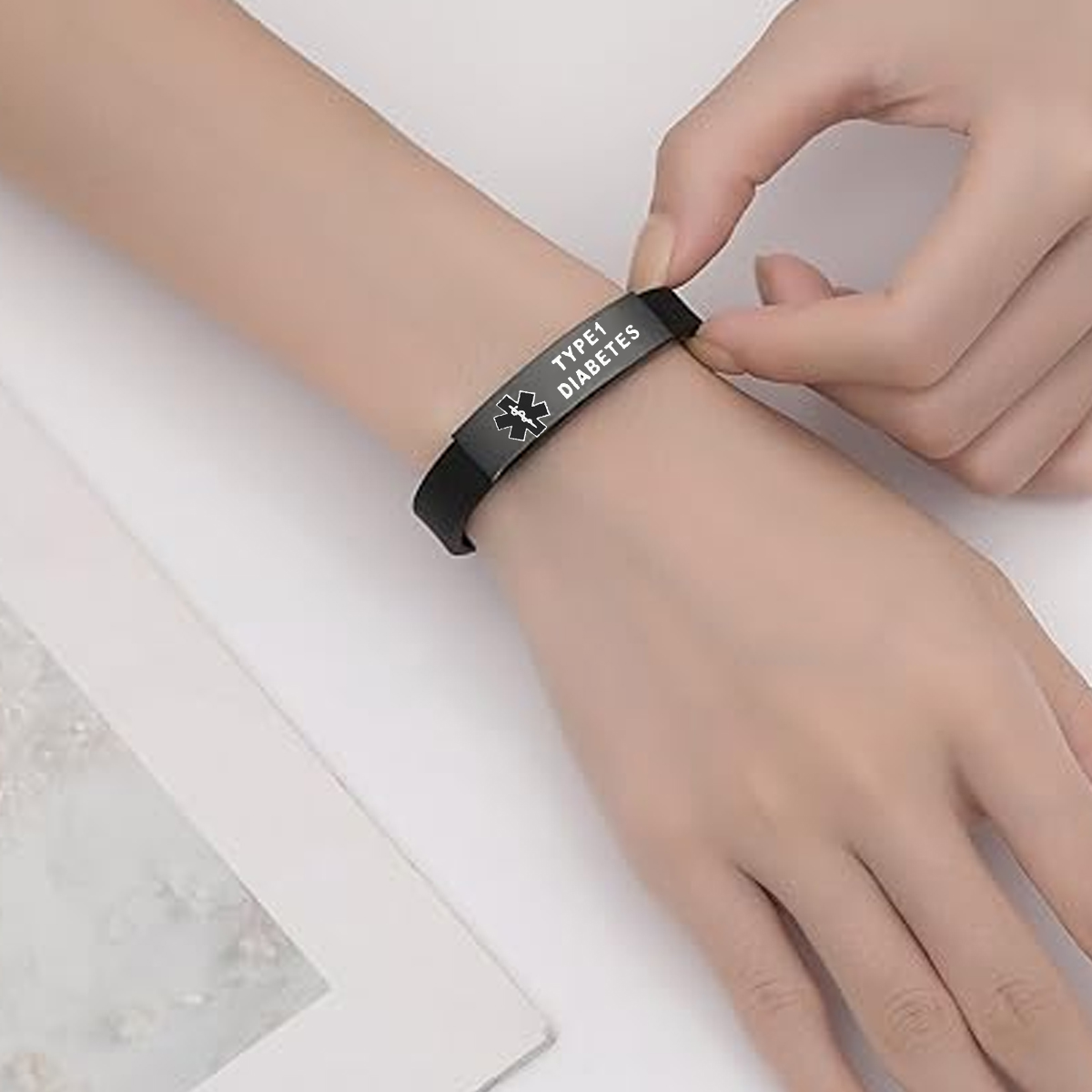 Die Hand einer Person trägt ein schwarzes medizinisches ID-Armband mit der Aufschrift TYP 1 DIABETES.