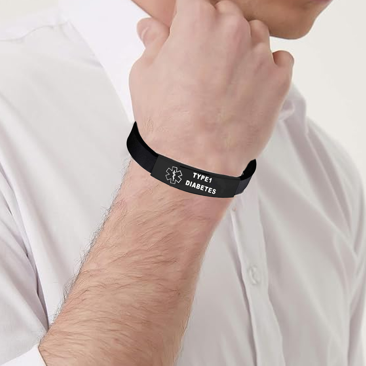 Person trägt ein schwarzes medizinisches ID-Armband. Das Armband trägt die Aufschrift 'TYPE 1 DIABETES'.