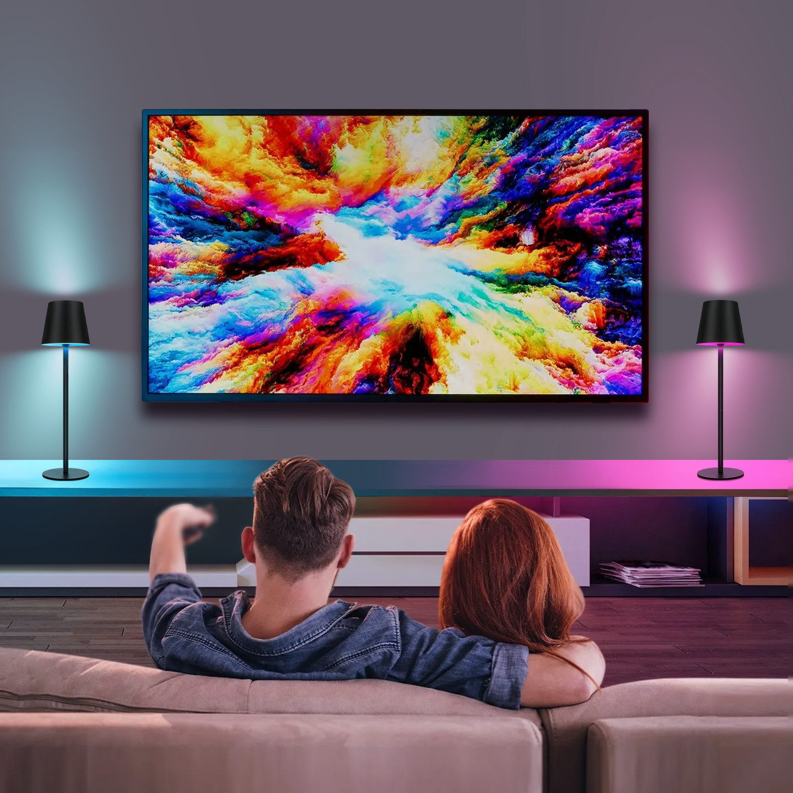 Para oglądająca telewizję z kolorową sztuką abstrakcyjną, dwie lampy.