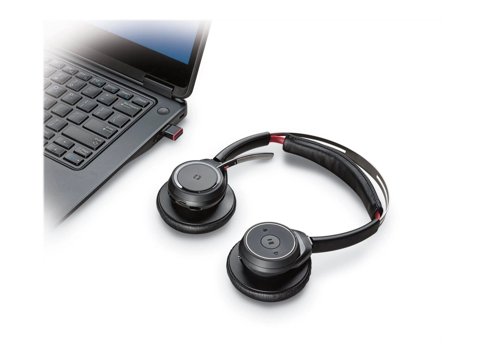Schwarzes Headset neben einem Laptop mit eingestecktem USB-Dongle.