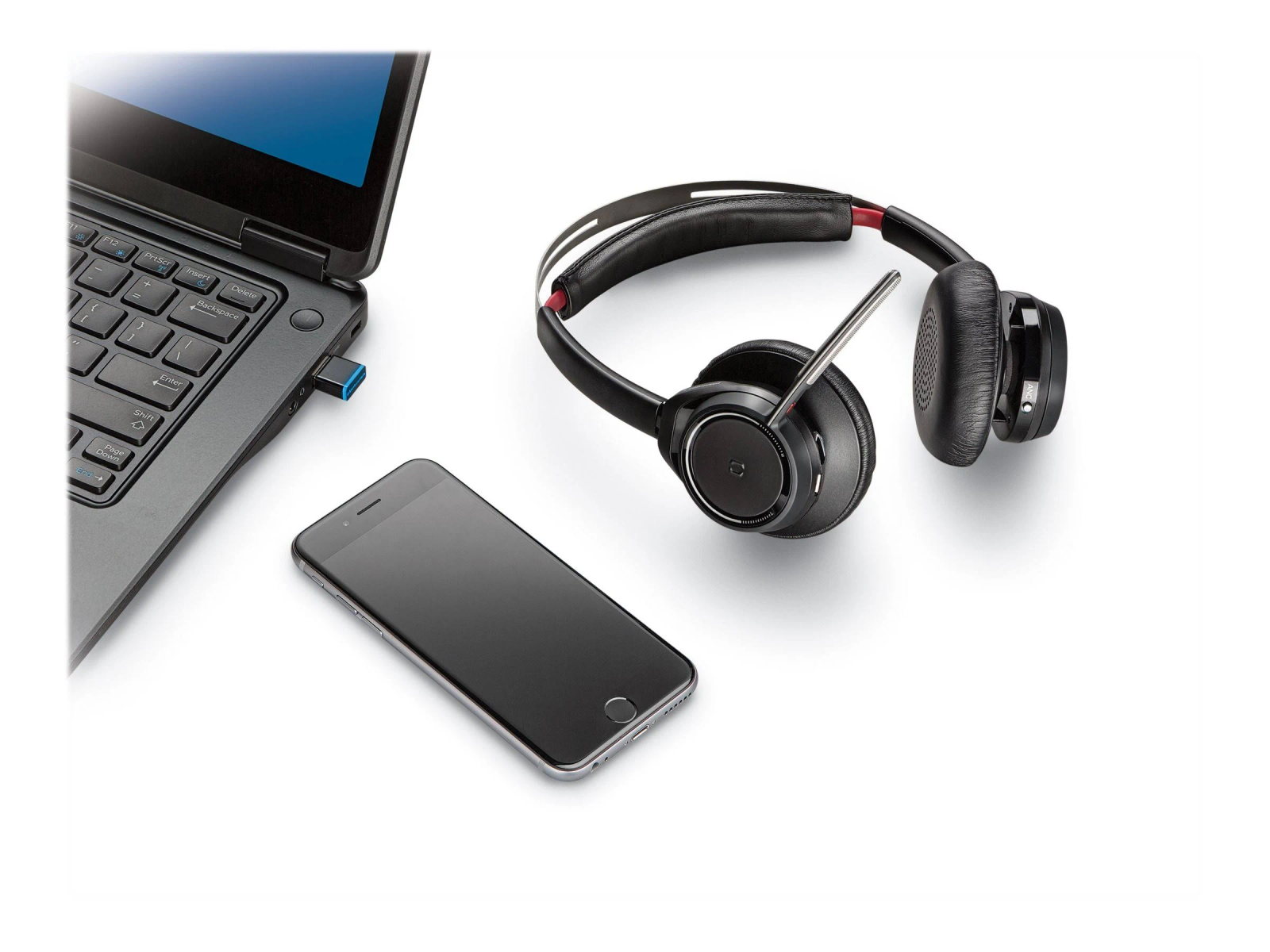 Headset an Laptop und Smartphone angeschlossen. Das Headset ist schwarz und das Telefon liegt auf weißem Untergrund.