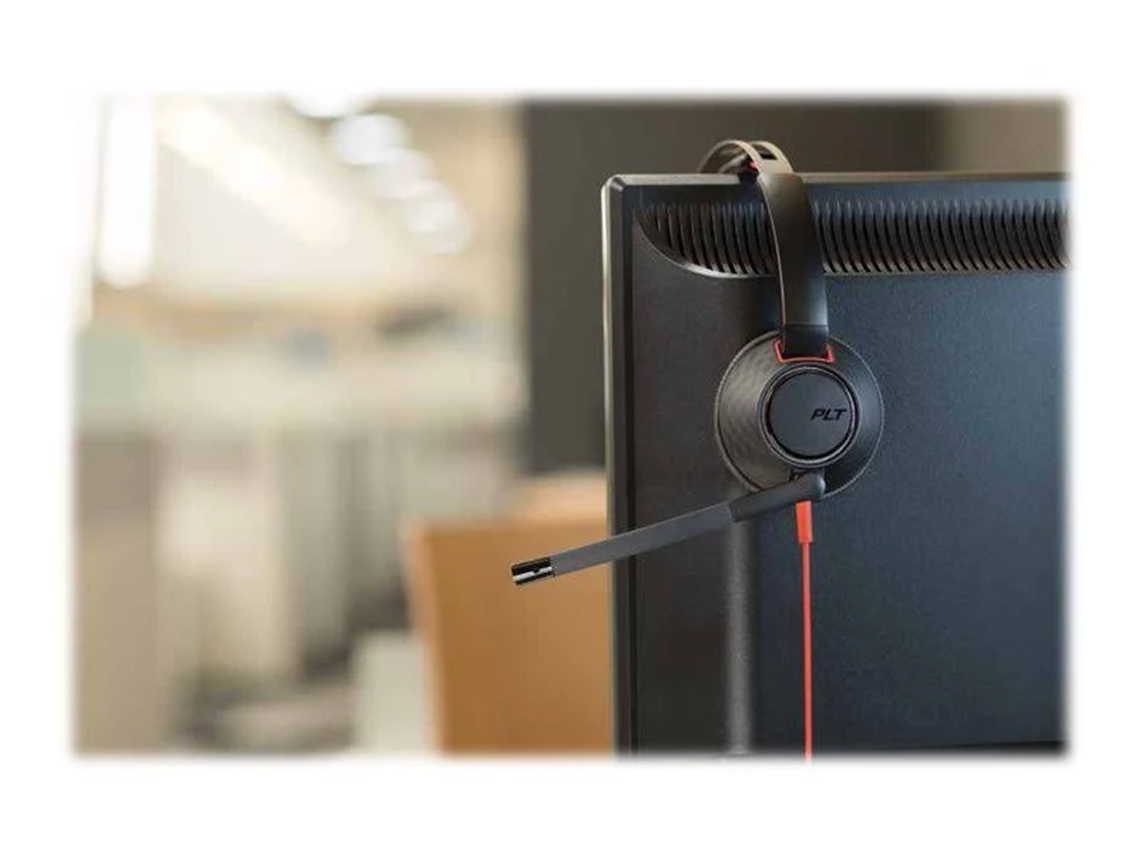 Słuchawki na monitorze komputera, z mikrofonem i czerwonym kablem.