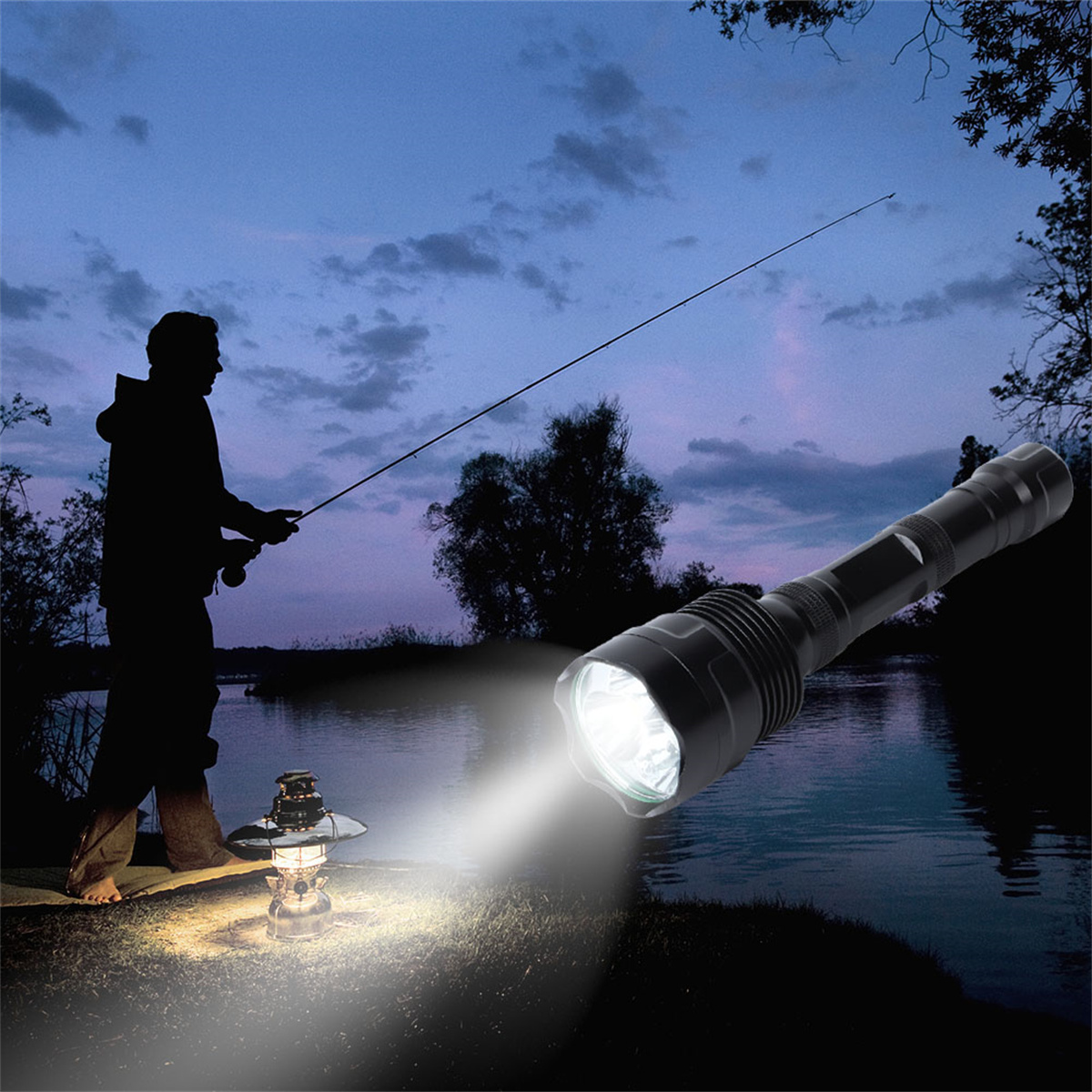Ein Mann fischt nachts, beleuchtet von einem Scheinwerfer einer großen, schwarzen Taschenlampe. Eine Laterne gibt auch Licht.