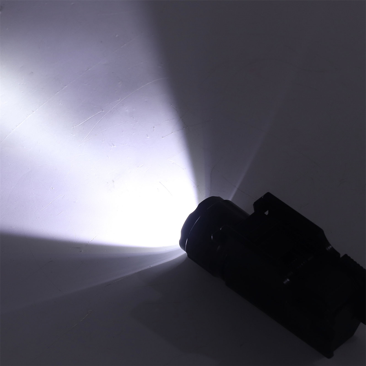 Eine Taschenlampe, die einen hellen weißen Lichtstrahl vor weißem Hintergrund projiziert.