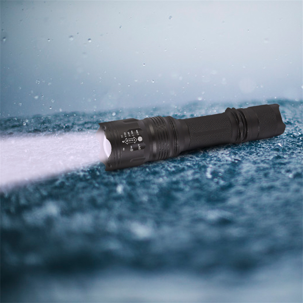 Schwarze, wasserdichte Taschenlampe, die einen weißen Strahl auf eine nasse Oberfläche wirft, mit Wassertropfen.