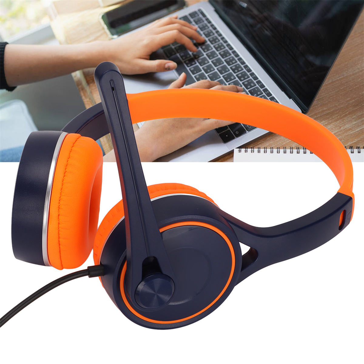 Orange und marineblaue Kopfhörer mit Mikrofon neben einem Laptop und Händen, die darauf tippen.