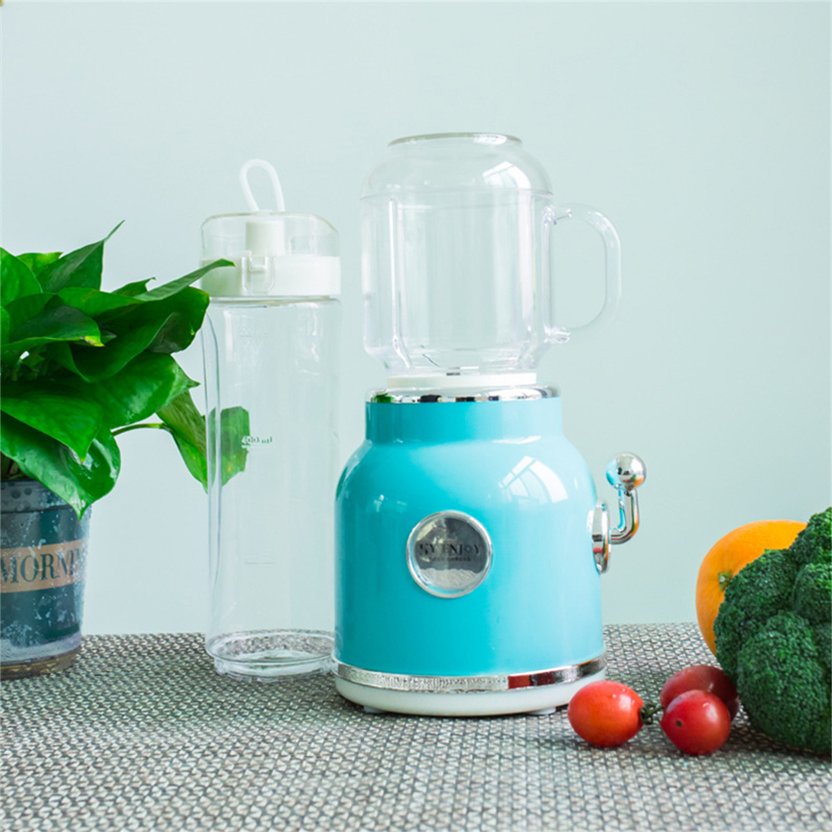 Ein blauer Getränkespender mit einer Wasserflasche und Lebensmitteln, wie Brokkoli und Tomaten.