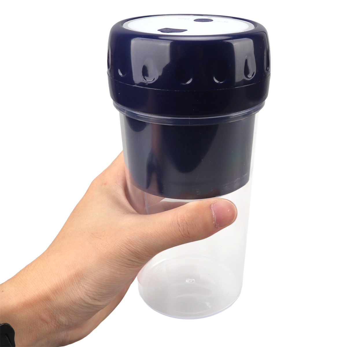 Hand hält einen blau-transparenten Becher mit dunkelblauem Deckel.