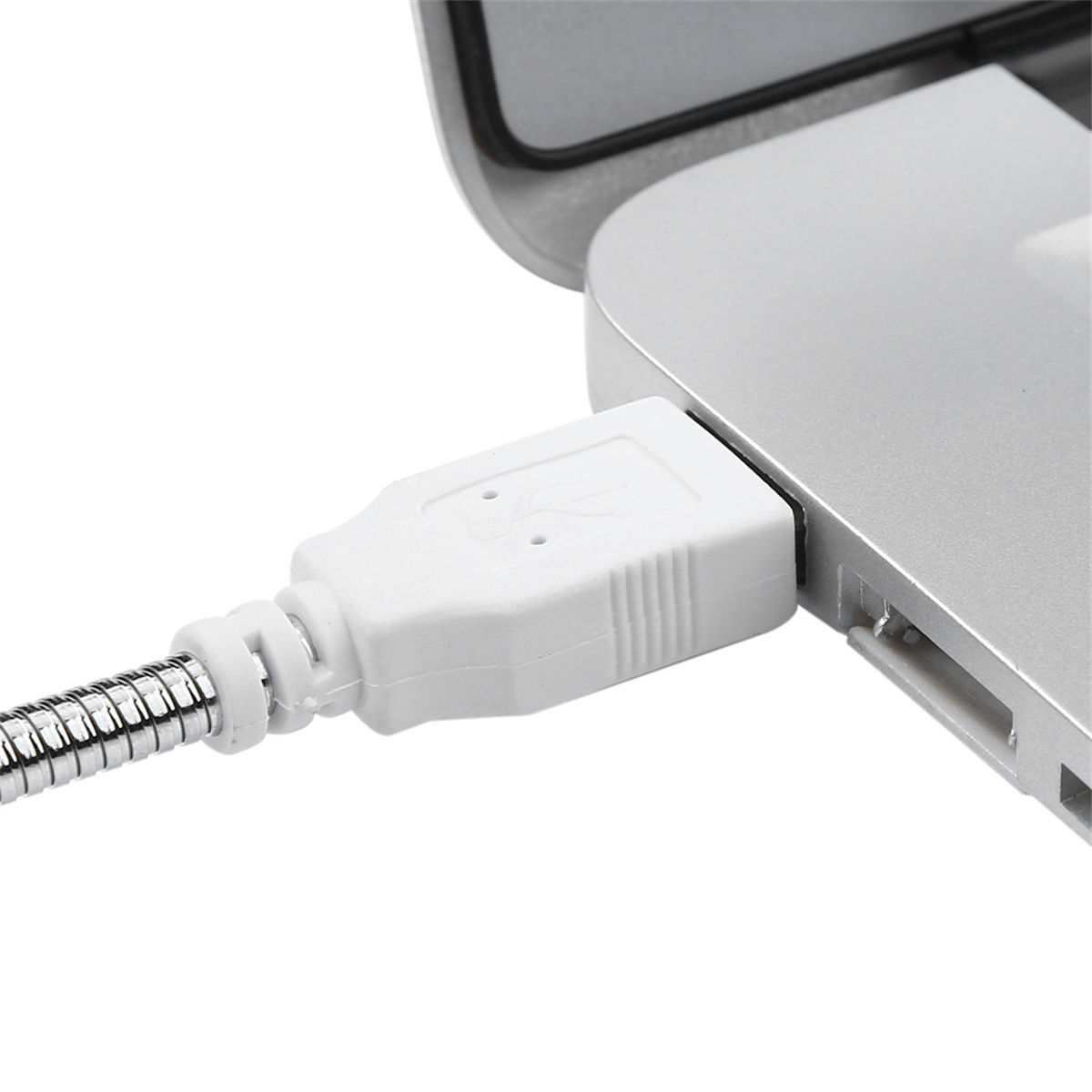Nahaufnahme eines weißen USB-A-Anschlusses, der in einen silbernen Laptop gesteckt ist.