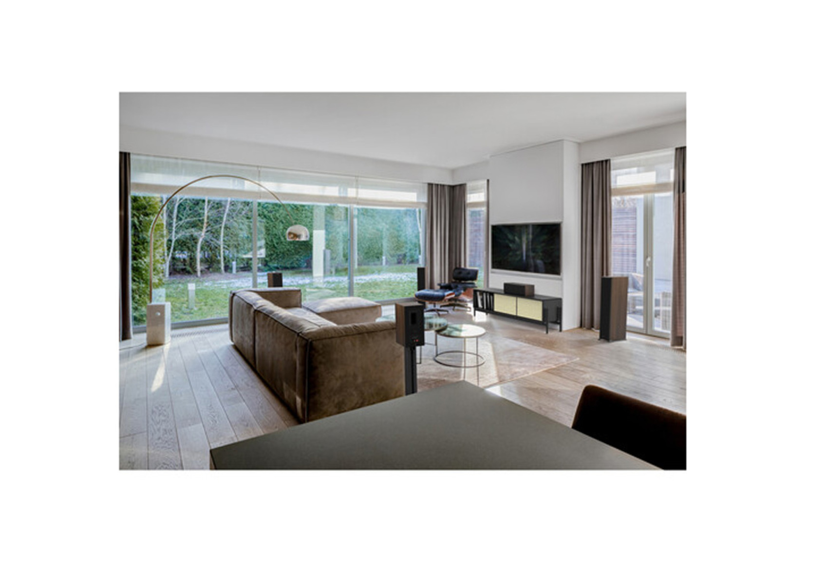 Modernes Wohnzimmer mit großen Fenstern, Möbeln und Ausblick.