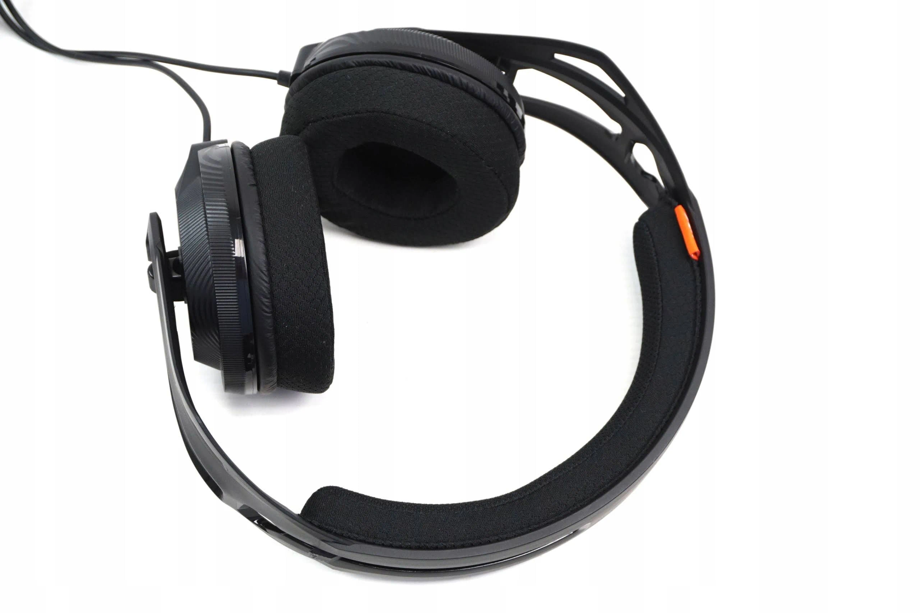 Casque noir avec écouteurs et bandeau, sur une surface blanche.