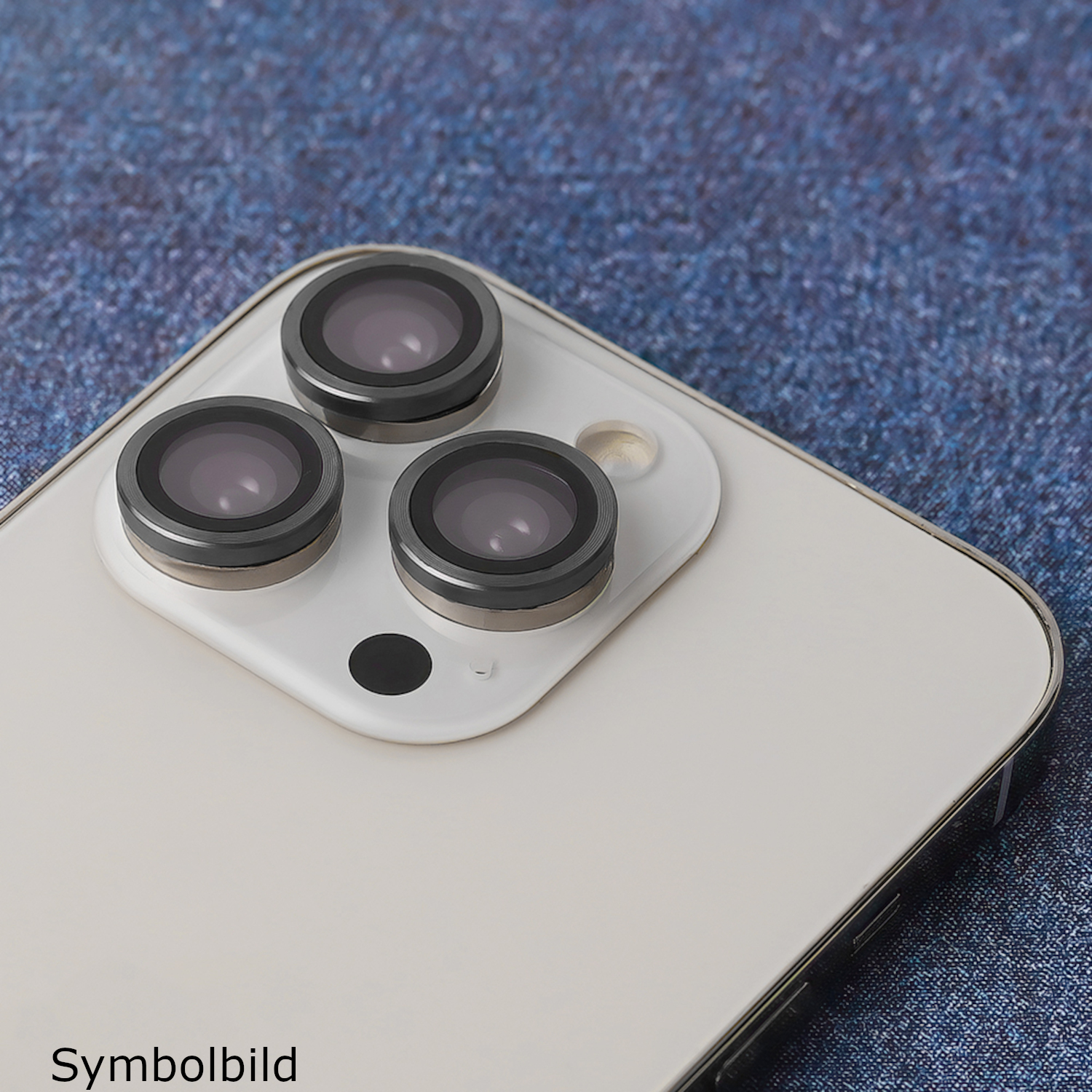 Telefon mit drei Kameralinsen auf strukturierter blauer Oberfläche, Text 'Symbolbild'.