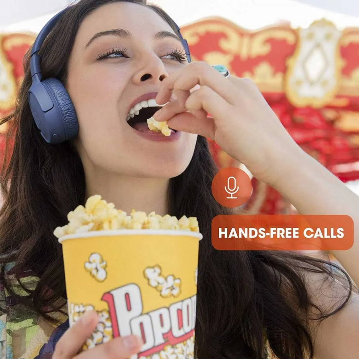 Mujer comiendo palomitas, con auriculares, con etiqueta 'Llamadas manos libres' sobre blanco.