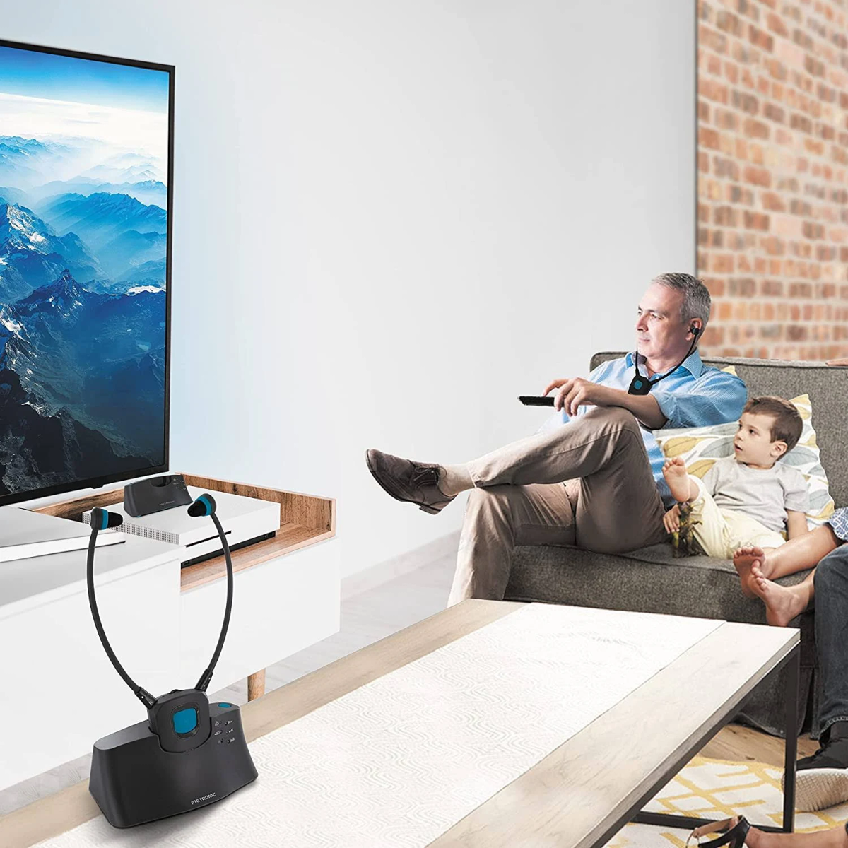 Escena de sala de estar con hombre, niño y TV mostrando un paisaje montañoso.