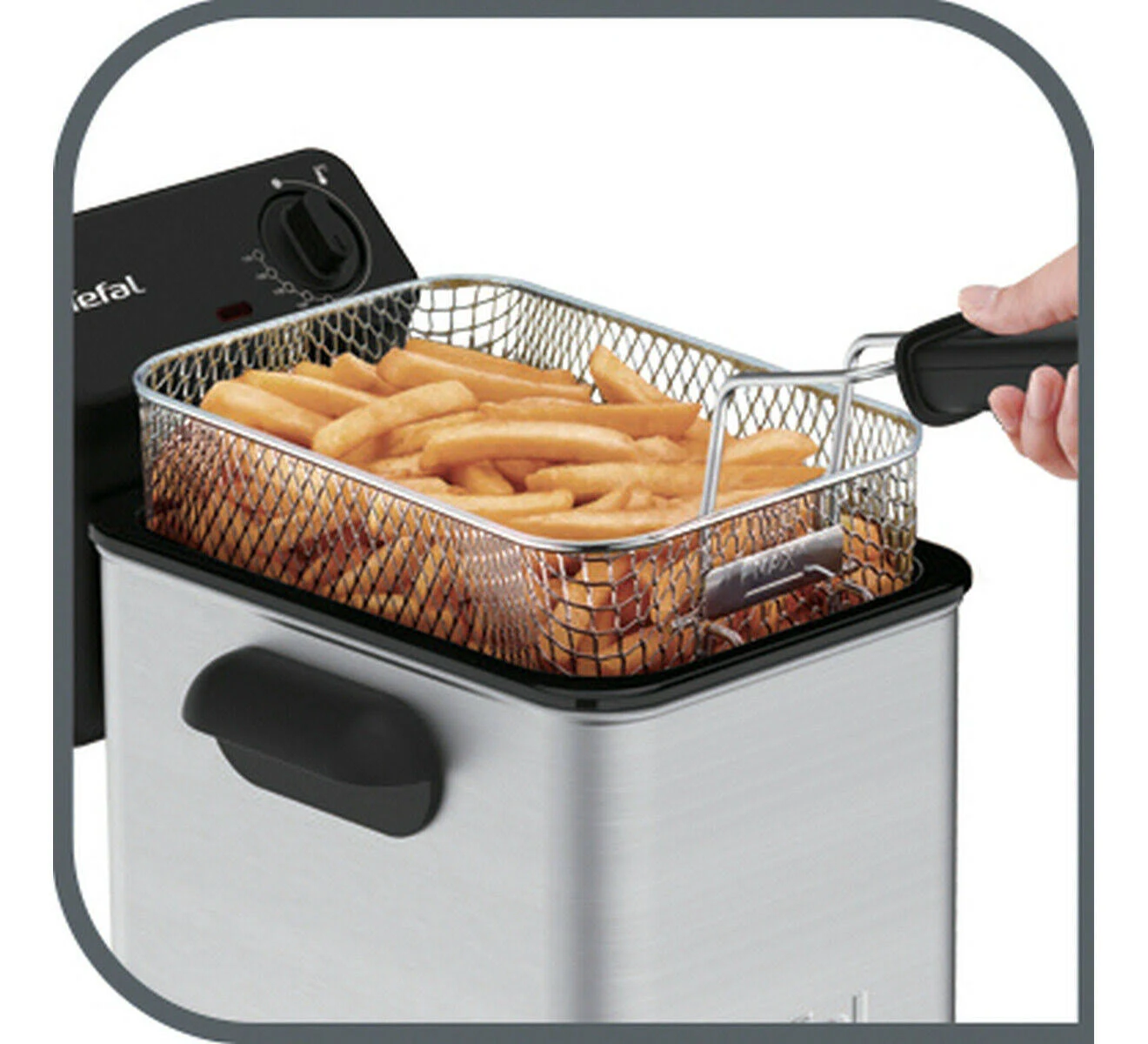 Frytki w metalowym koszu wyjęte ze srebrnej frytkownicy.