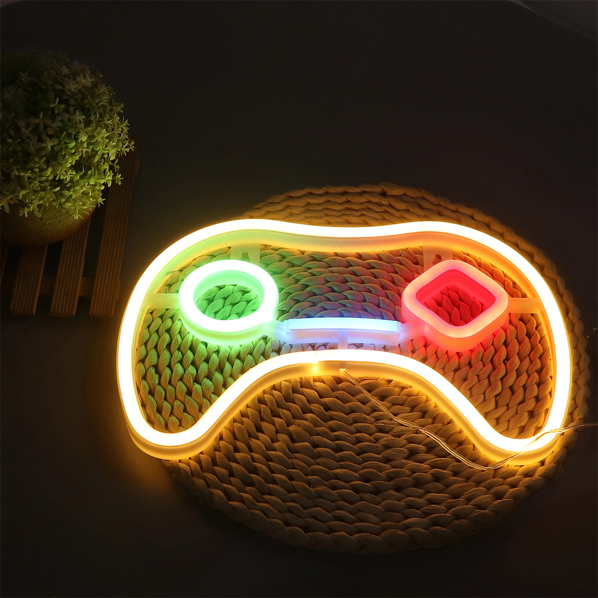 Neon-Gaming-Controller-Licht auf einer gewebten Matte, mit grünem, rotem und blauem Licht. Dunkler Hintergrund.