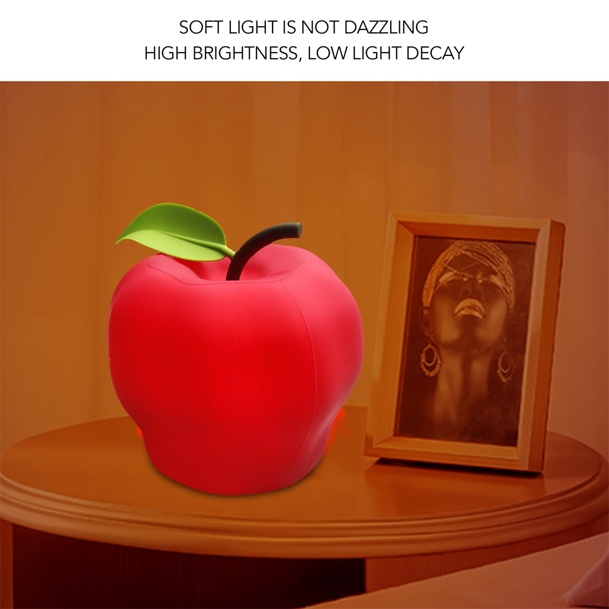 Eine rot-apfelförmige Lampe und ein gerahmtes Bild auf einem Holztisch. Text auf Englisch.