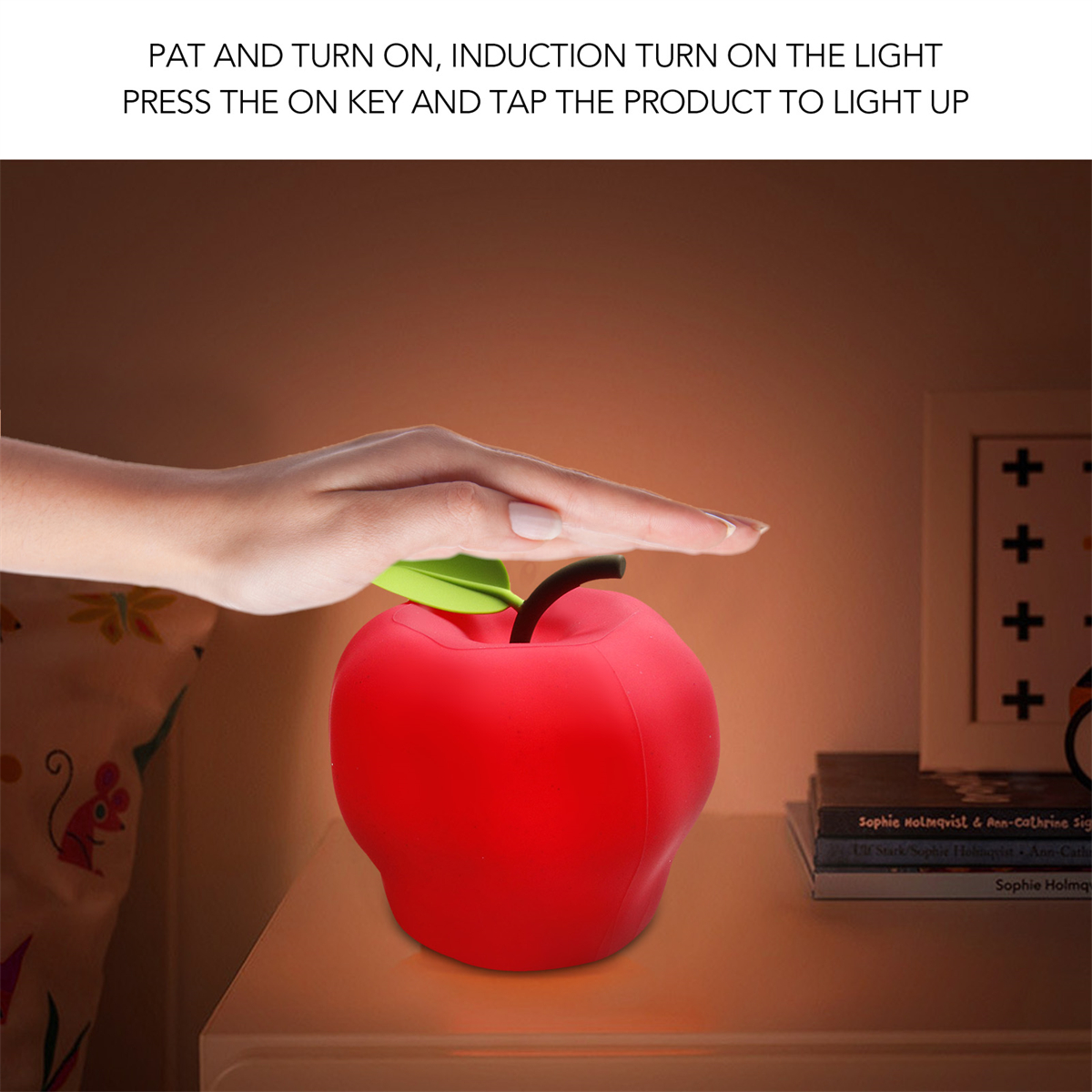 Rotes apfelförmiges Licht auf einem Nachttisch. Hand berührt Apfel, Text an der Wand.
