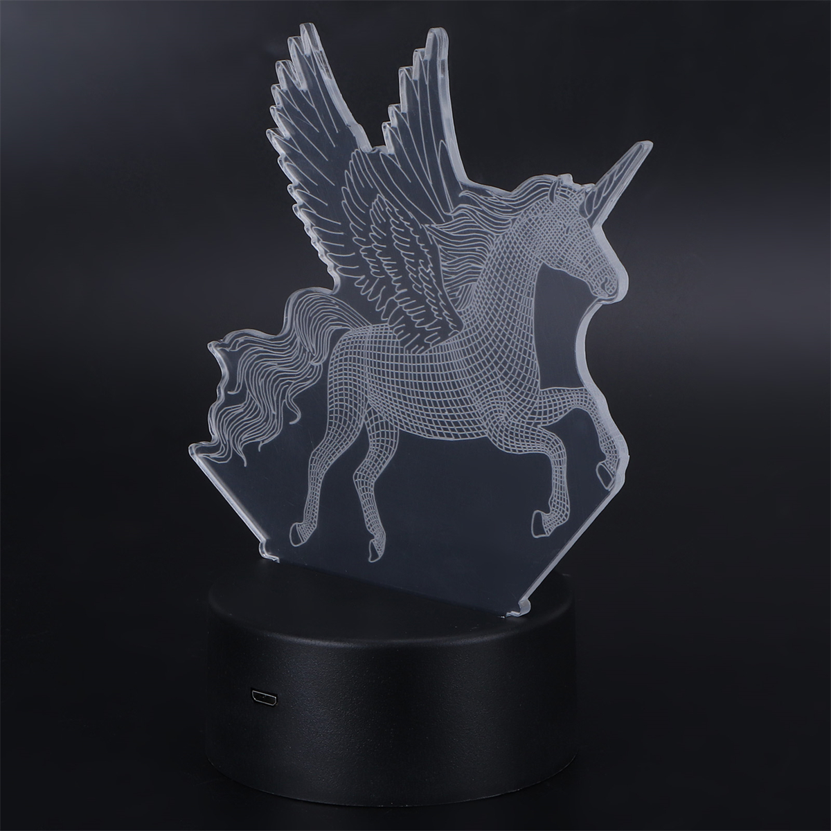 Eine klare Einhornfigur mit Flügeln, die auf einem schwarzen Sockel steht. Es wird von Licht beschienen.