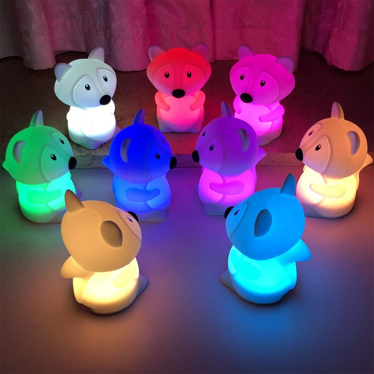 Neun leuchtende fuchsförmige Nachtlichter in verschiedenen Farben, kreisförmig angeordnet.