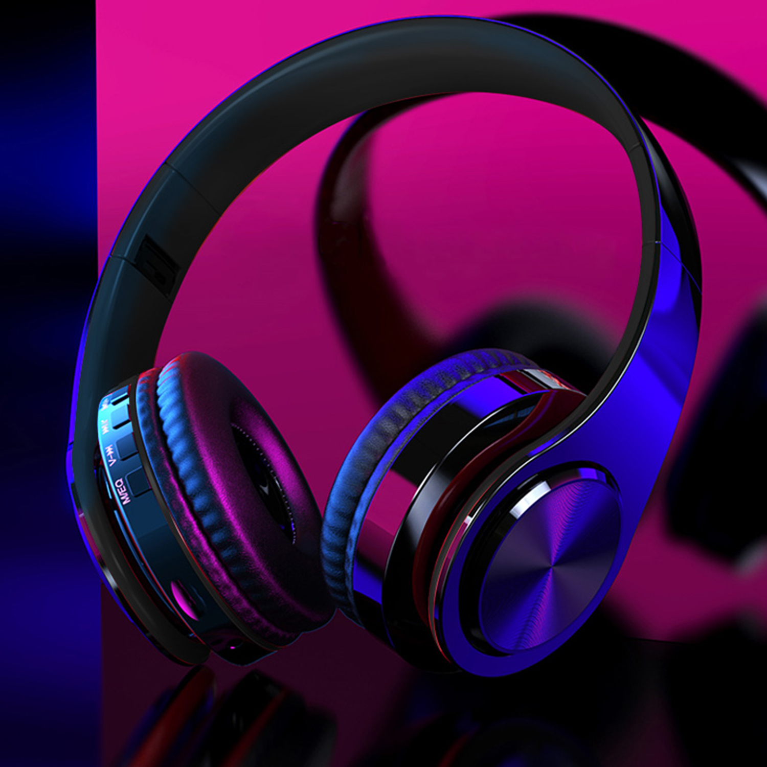 Schwarze und blaue Kopfhörer mit Metallic-Finish, die sich auf einer dunklen Oberfläche spiegeln, mit rosa Hintergrund.