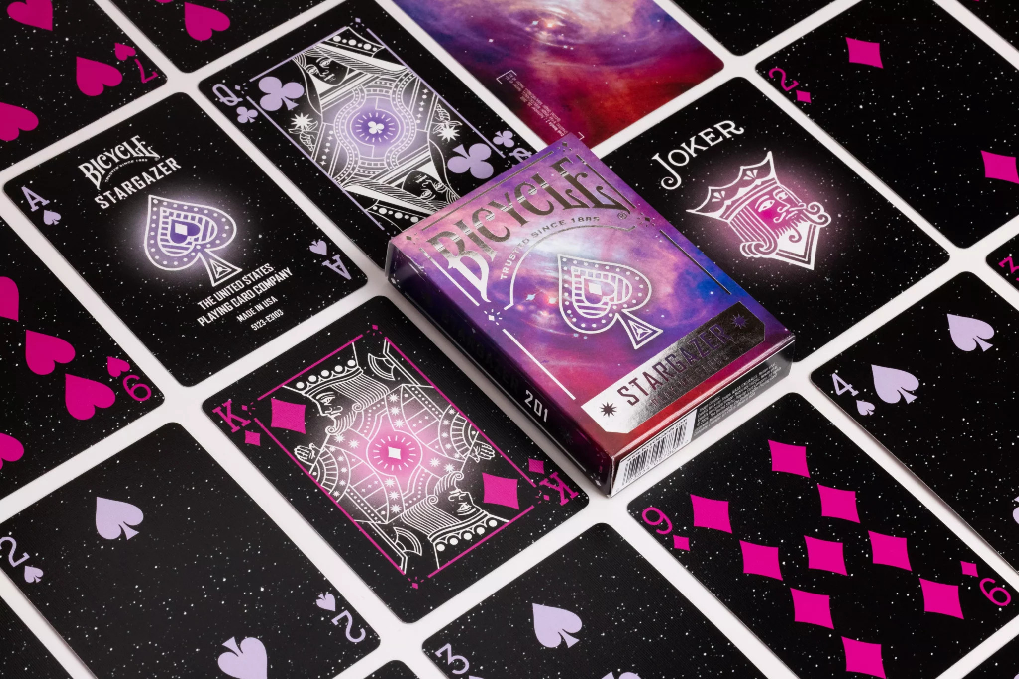 Ein Kartenspiel Bicycle Star Gazer auf einer weißen Oberfläche, aufgefächert. Die Box ist in der Mitte.