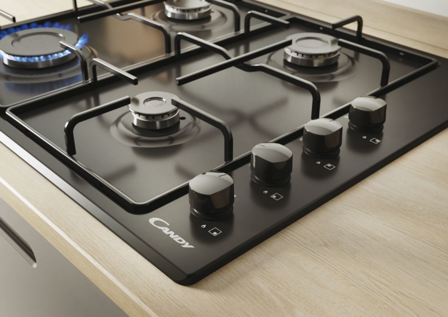 Czarna kuchenka gazowa z czterema palnikami i pokrętłami.