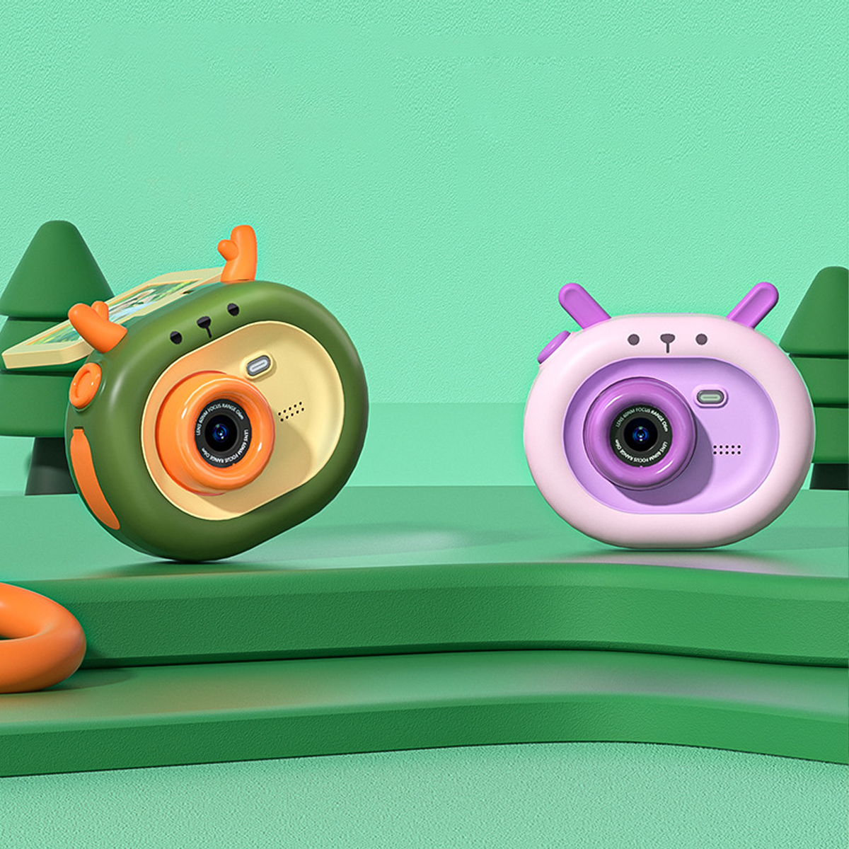 Dwa zabawki aparaty, zielony i różowy. Zielony ma rogi. Scena na zielonej platformie z zielonymi drzewami w tle.