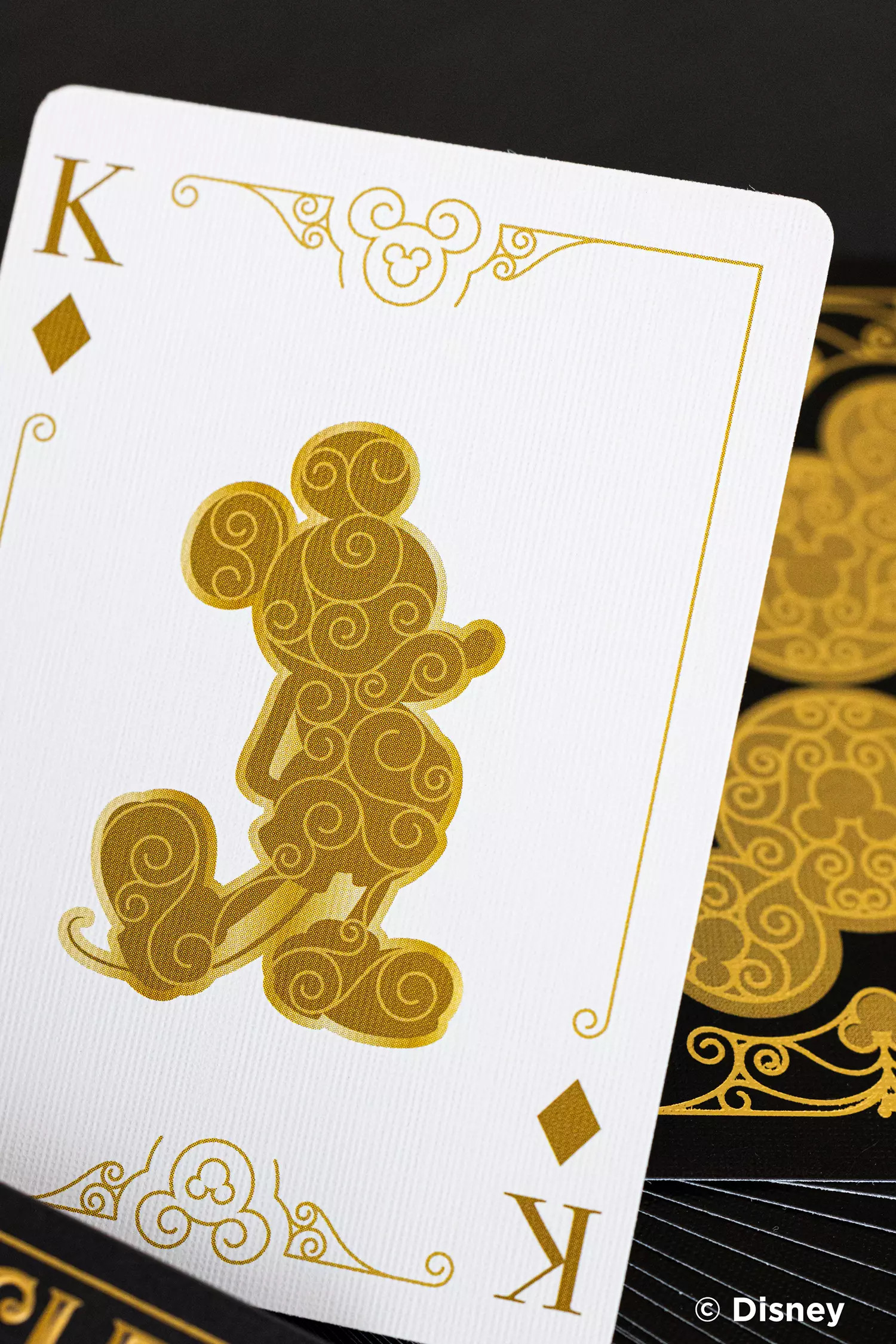Spielkarte mit Micky Maus. Goldener Micky auf weißem Grund, schwarze Akzente.
