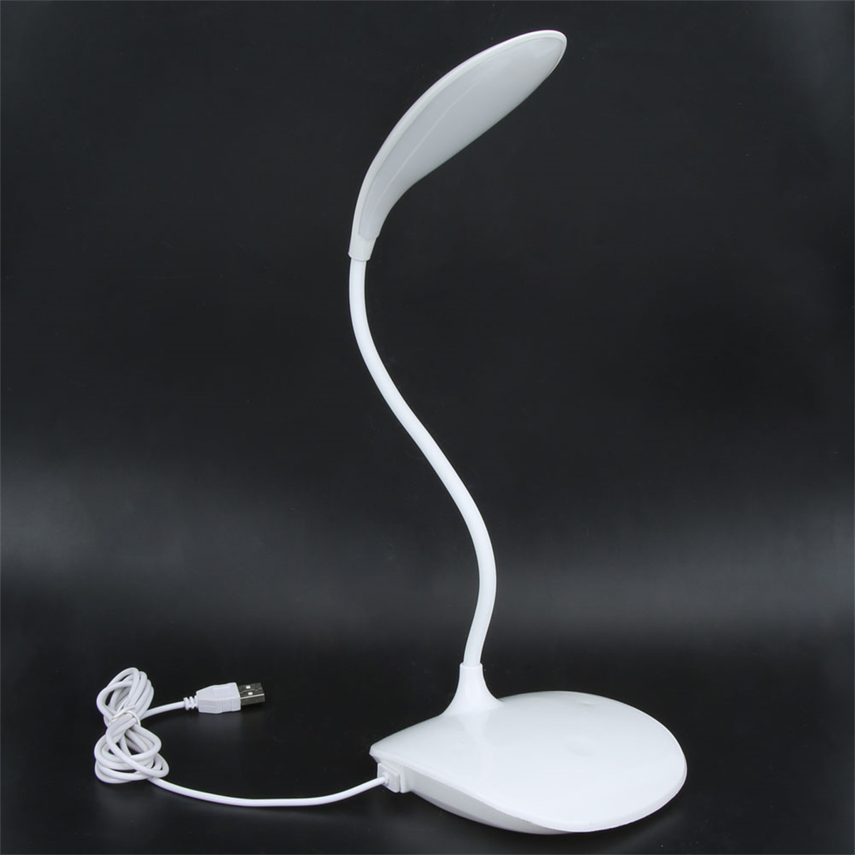 Weiße Schreibtischlampe mit geschwungenem Design, an ein USB-Kabel angeschlossen.