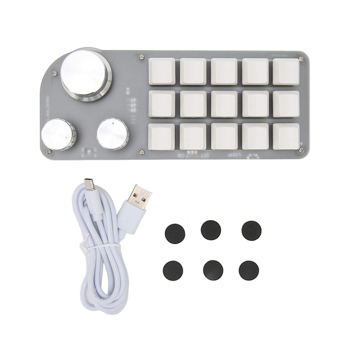 Grauer Controller mit mehreren Tasten und Drehreglern. Enthält ein USB-Kabel und Ersatzknöpfe.