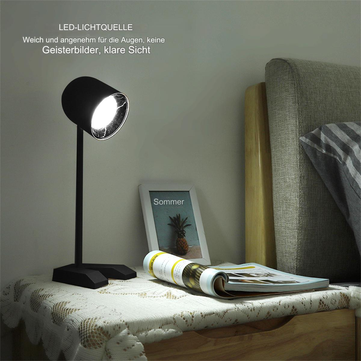 Eine schwarze Schreibtischlampe beleuchtet ein Zimmer mit einer Zeitschrift und einem Bilderrahmen auf einem Nachttisch. Die Lampe ist angewinkelt.