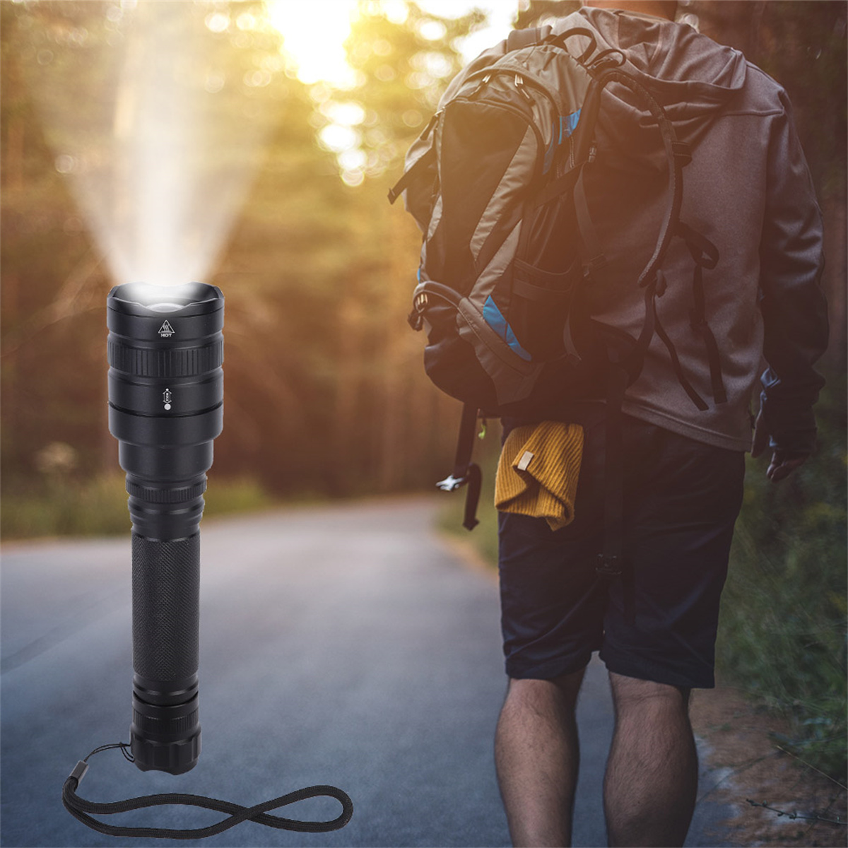 Eine schwarze Taschenlampe, die einen Lichtstrahl aussendet. Eine Person mit Rucksack geht im Hintergrund.
