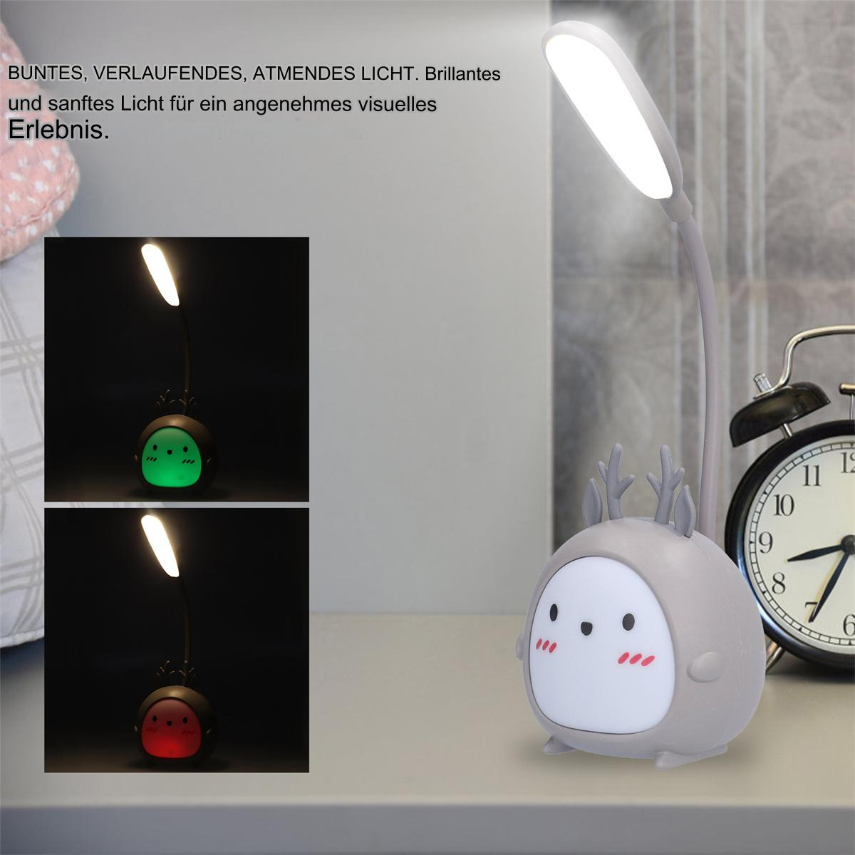 Eine niedliche hirschförmige Lampe leuchtet in zwei Farben. Ein schwarzer Wecker steht im Hintergrund auf dem Tisch.