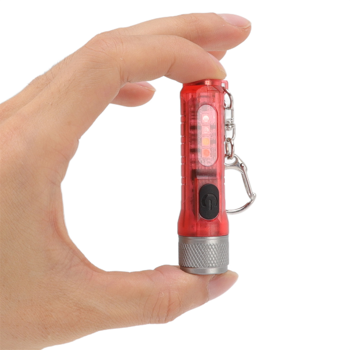 Eine rote Taschenlampe, die von einer Hand gehalten wird. Sie hat einen Metallsockel und einen Knopf.