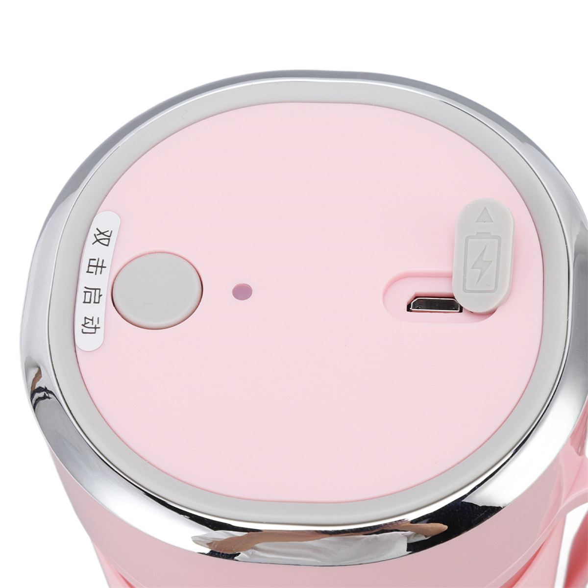 Draufsicht auf ein rosa-silbernes Gerät mit Knopf und USB-Anschluss. Schwarzer Hintergrund.