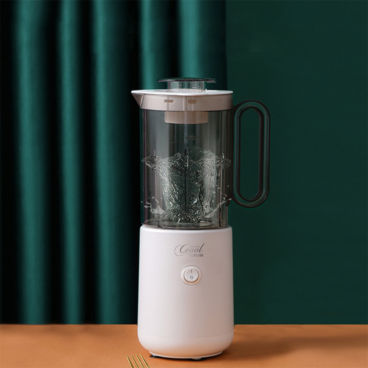 Ein weißer und klarer Mixer. Der Mixer hat eine weiße Basis, ein klares Glas und einen dunklen Griff.
