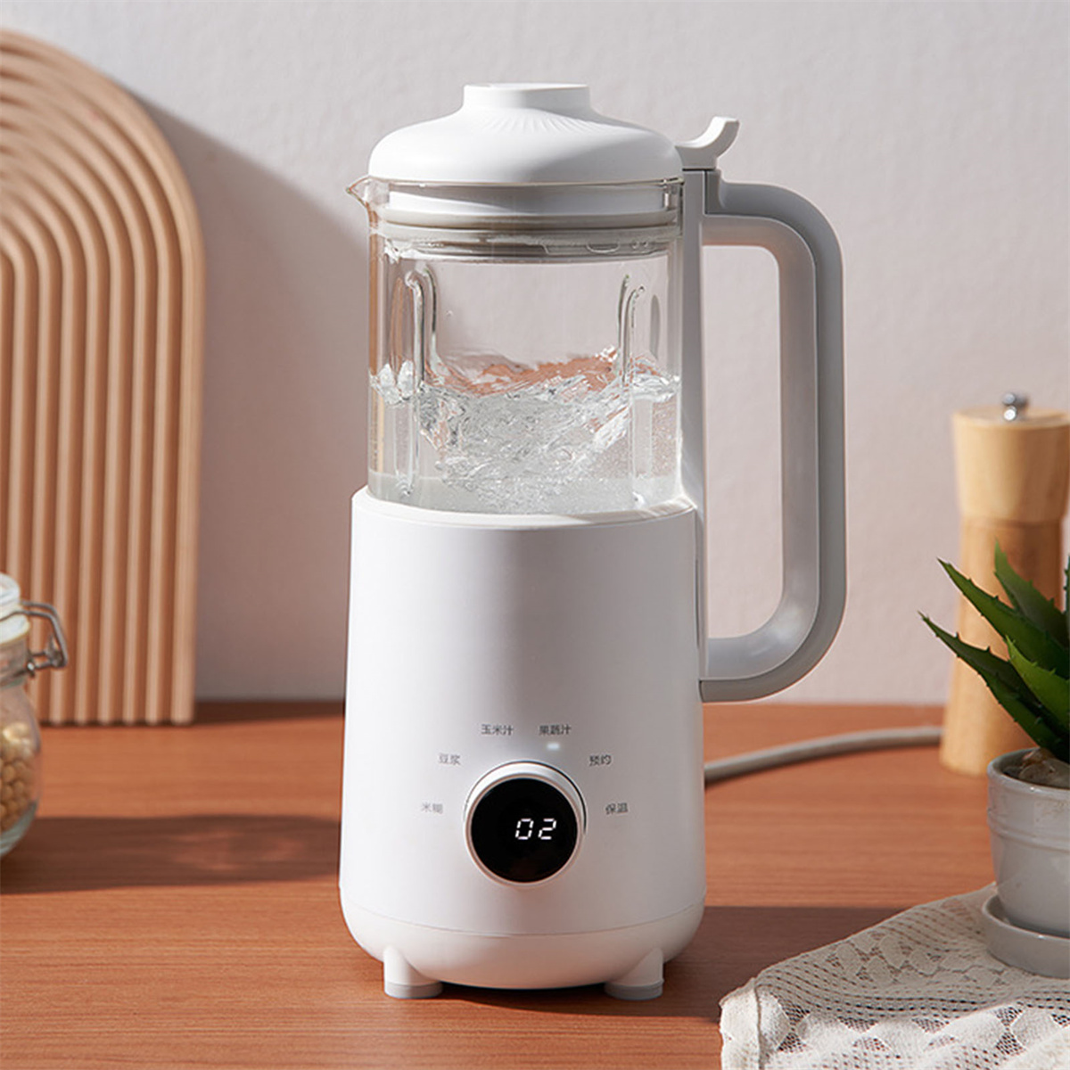 Ein weißer Mixer mit transparentem Behälter, gefüllt mit Wasser. Digitalanzeige.