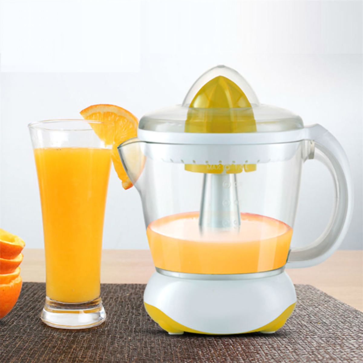 Eine Orangensaftpresse mit Saft darin und ein Glas Saft daneben. Eine Orangenscheibe auf dem Glas.