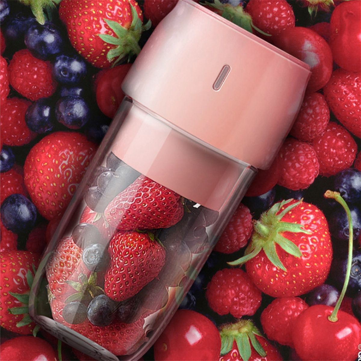 Mixer gefüllt mit Erdbeeren und Blaubeeren. Rosa Oberteil. Rote Beeren im Hintergrund.