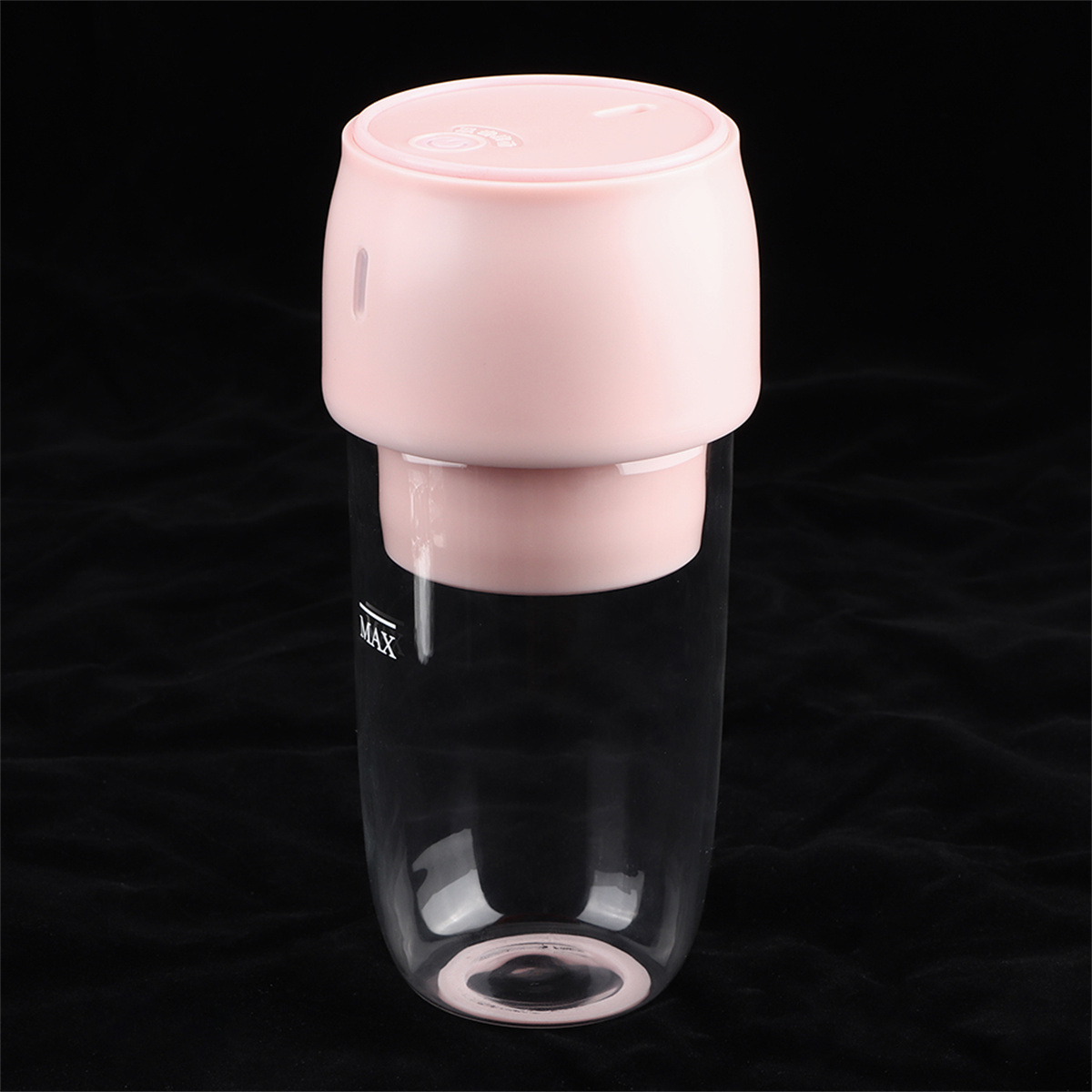 Rosa und klarer Mixer, mit rosa Oberteil, klarer Mixbecher und schwarzem Hintergrund.