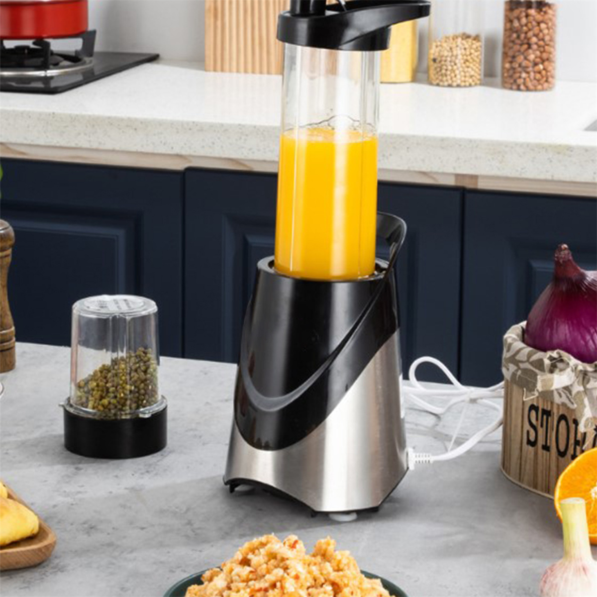 Ein Mixer mit gelber Flüssigkeit, ein Glas mit grünen Bohnen und andere Gegenstände auf der Arbeitsplatte.