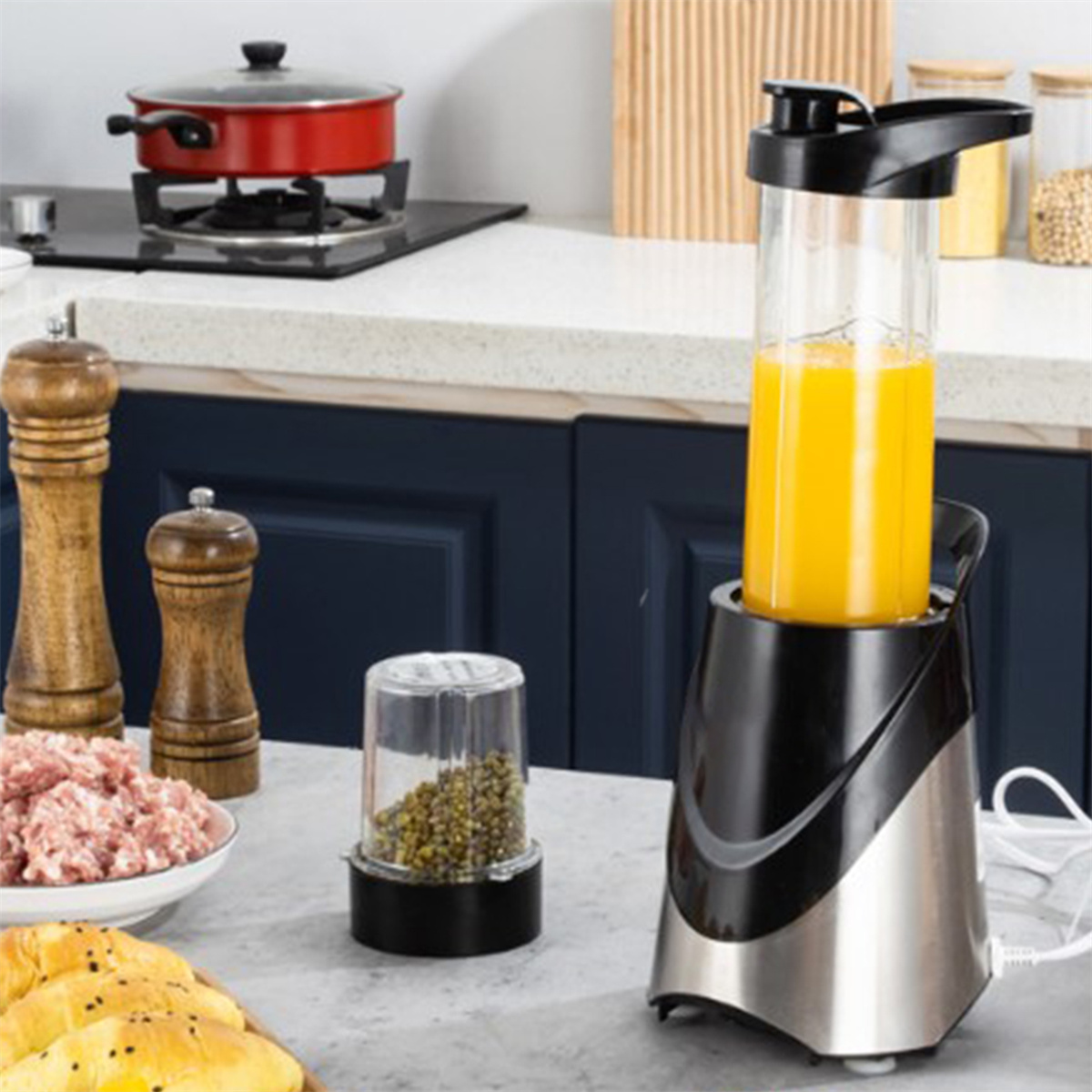 Ein Mixer mit Saft und ein kleiner Behälter stehen auf einer Theke. Hintergrund: Küche mit Herd.