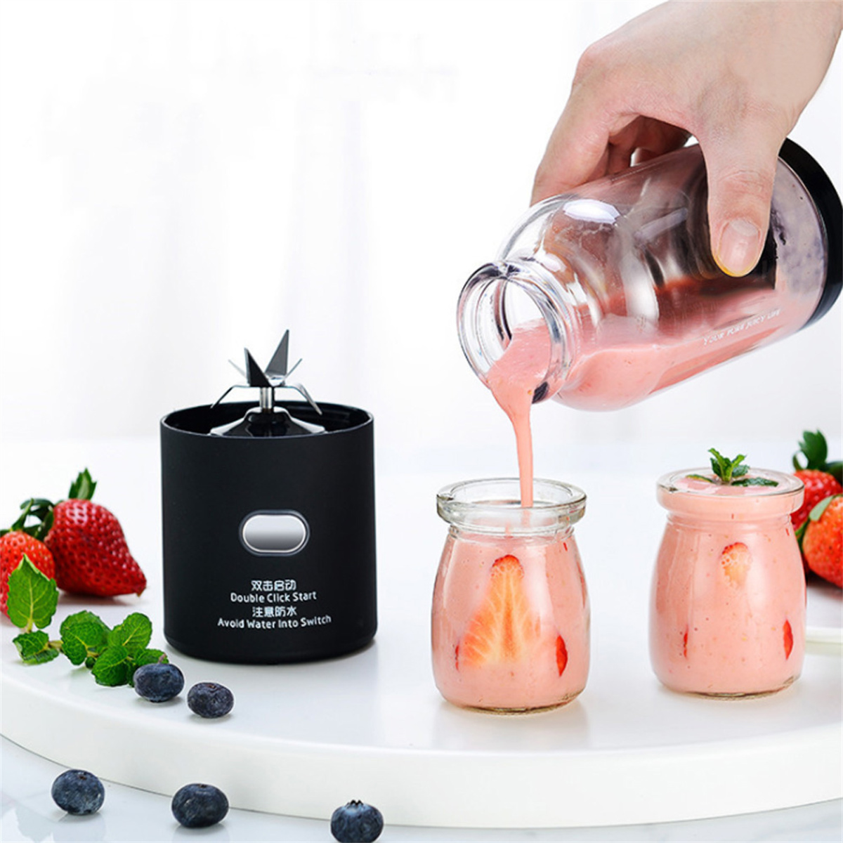 Ein Smoothie wird in zwei kleine Gläser gegossen. Blaubeeren und Erdbeeren sind vorhanden.