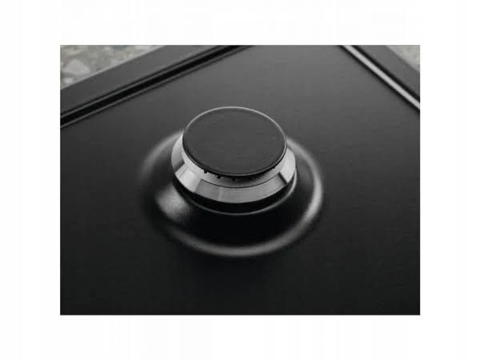 Czarny palnik kuchenki gazowej ze srebrnym pierścieniem. Czarna powierzchnia.